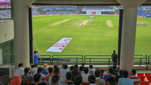 A cricket ground seen from a covered stand