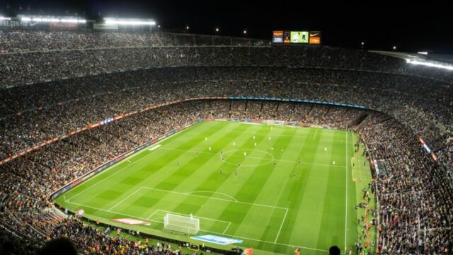 A football stadium under floodlights at night