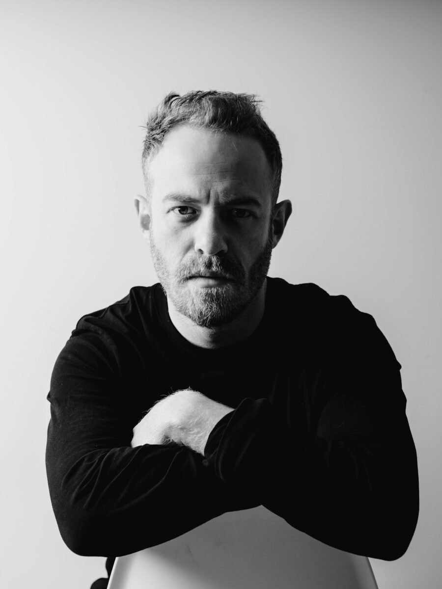 Black-and-white portrait of Joe, arms folded
