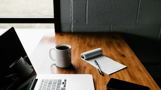 Laptop, notebook and coffee on a desk