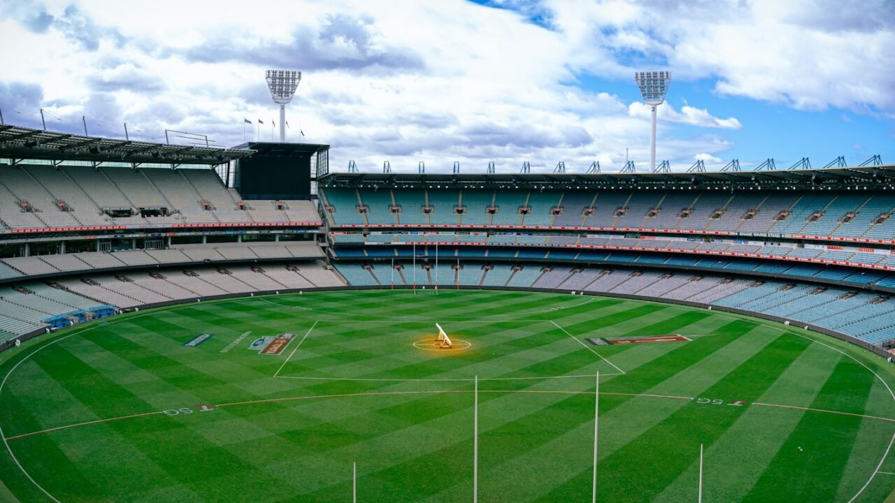 A cricket ground with stands and a green outfield